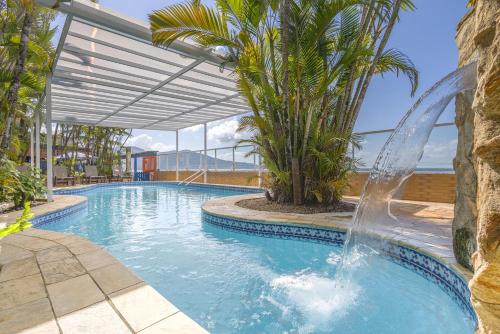 a swimming pool with a fountain in a resort at Kaliman Pousada in Ubatuba