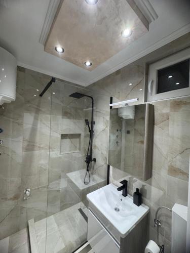 a bathroom with a sink and a shower at Georgeous lux apartment # 2 in Foča