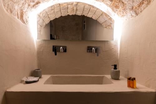 a bathroom with a large bath tub with an arch above it at MALOLÙ luxurysuite in Ostuni