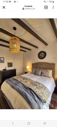 a bedroom with a large bed and a chandelier at La Cour in Villefagnan