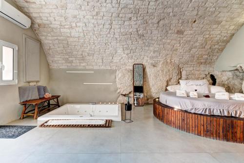 a bedroom with a bed and a bath tub at MALOLÙ luxurysuite in Ostuni
