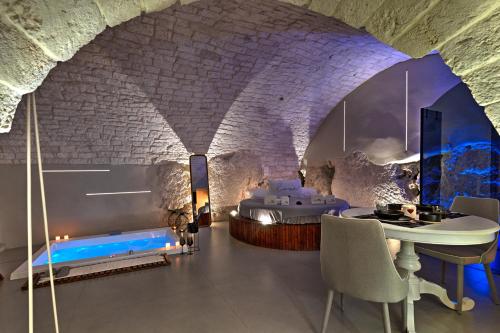 a room with a bed and a table and chairs at MALOLÙ luxurysuite in Ostuni