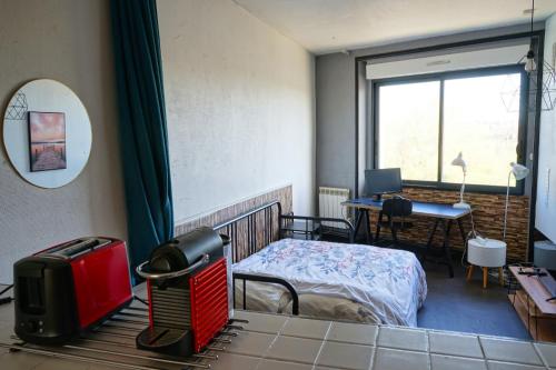 sypialnia z łóżkiem, biurkiem i oknem w obiekcie Appartement bord de vilaine, proche centre et gare w mieście Redon