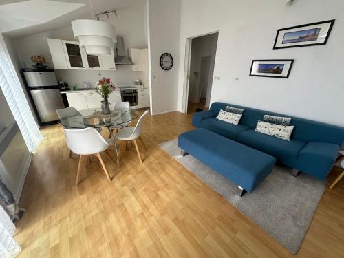 a living room with a blue couch and a table at Apartments Charming in Zadar