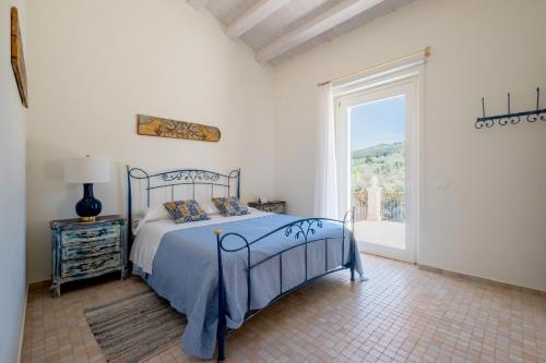 a bedroom with a bed and a large window at Villa Santa Margherita in Chiaramonte Gulfi