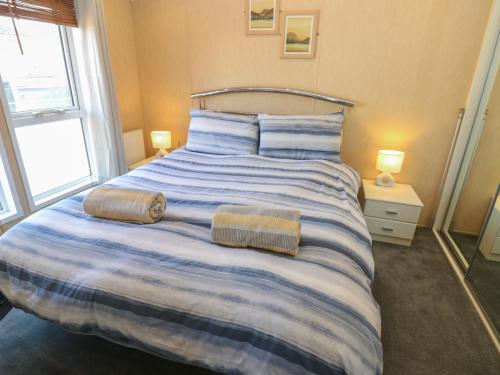 a bedroom with a large bed with two towels on it at New Horizon in Carlisle