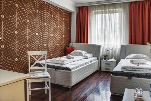 a hotel room with two beds and a window at Éjjelibagoly Vendégház in Szentes