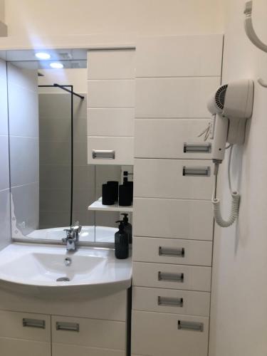 a bathroom with a sink and a mirror at Éjjelibagoly Vendégház in Szentes