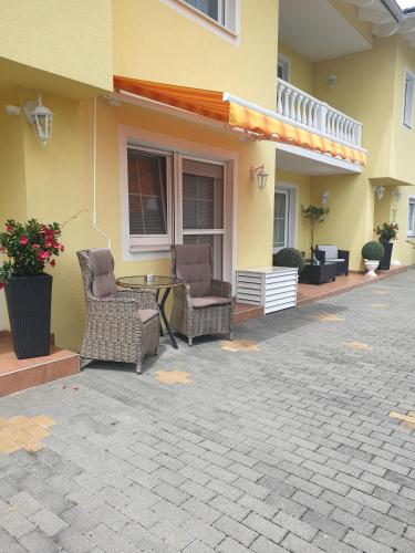 two chairs and a table outside of a house at Villa Katharina in Rust