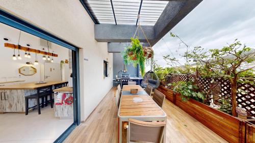 a room with a table and a kitchen and a balcony at The Galilee Flame duplex in Shlomi