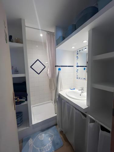 une salle de bain blanche avec un lavabo et une douche dans l'établissement Les Ratiers, à Orcières