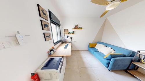 a living room with a blue couch and a window at The Galilee Flame duplex in Shlomi