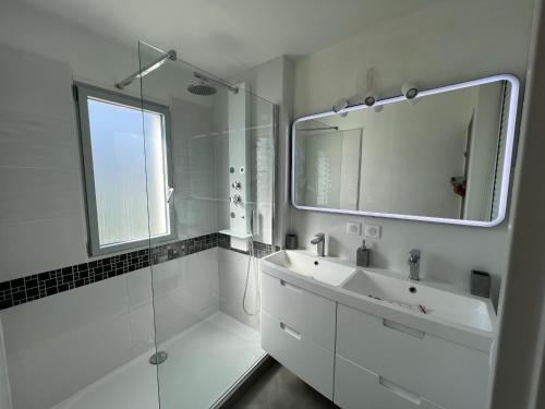 une salle de bain blanche avec un lavabo et un miroir dans l'établissement Superbe Terrasse ROOFTOP Vue Mer, à La Grande Motte