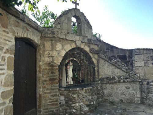 an old stone building with a cross on top of it at Agri Grotta dell'Eremita in Castelmezzano