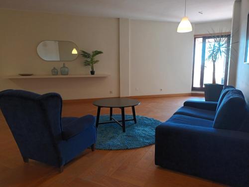 a living room with two blue chairs and a table at Vilar Oporto Hotel in Porto