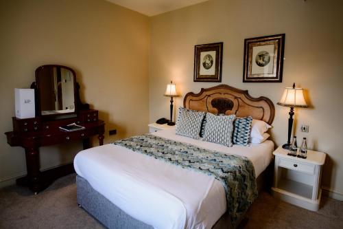 a hotel room with a large bed and a mirror at Ye Olde Bell Hotel & Spa in Retford