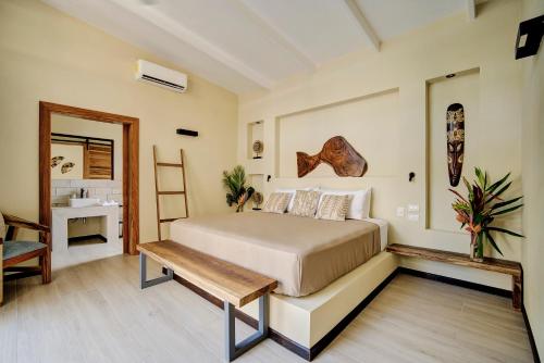 a bedroom with a bed and a wooden bench at Villas Roca del Caribe in Puerto Viejo