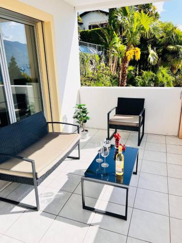 a patio with two chairs and a table at Spectacular penthouse with lake views in central Brissago in Brissago