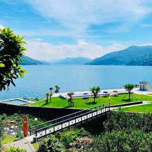 a bridge over a large body of water with mountains at Sunny modern Apartment Lake View Relax in Brissago