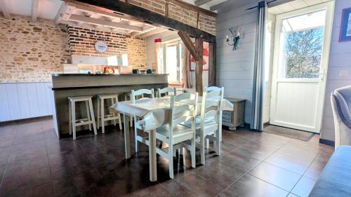 une cuisine et une salle à manger avec une table et des chaises dans l'établissement À la campagne proche du Mans, à Louplande