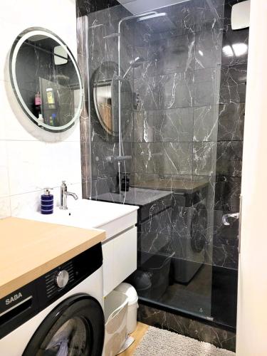 une salle de bain avec une machine à laver, un lavabo et une machine à laver dans l'établissement Coin de paradis à la montagne, à Villard-de-Lans