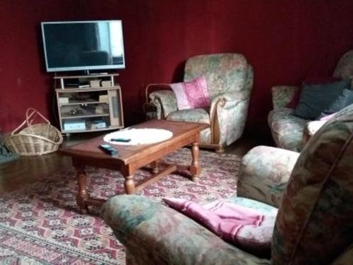 a living room with chairs and a table and a tv at Maison typique lorraine dans une ancienne ferme - FR-1-584-376 in Grand-Failly
