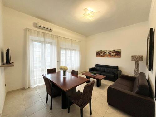 a living room with a table and a couch at Appartamenti le Conchiglie 1 by Ferrocino Holiday in Lido Conchiglie