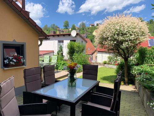 a patio with a glass table and chairs at Villa Ammonit in Pottenstein