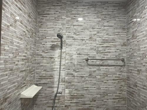 a shower in a bathroom with a stone wall at House at Hatyai Airport in Ban Thung Ri