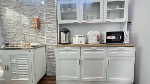 a kitchen with white cabinets and a counter with appliances at House at Hatyai Airport in Ban Thung Ri