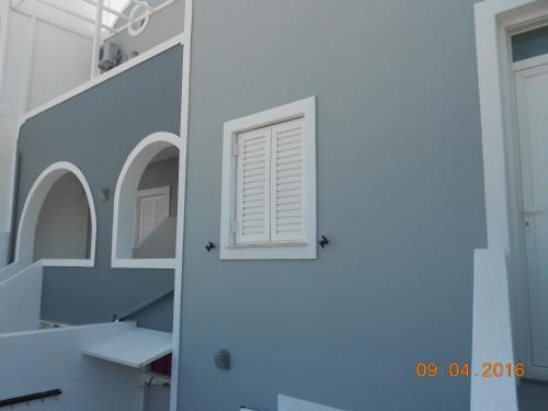 a white door with a window in a room at Rooms to let Rena in Monolithos