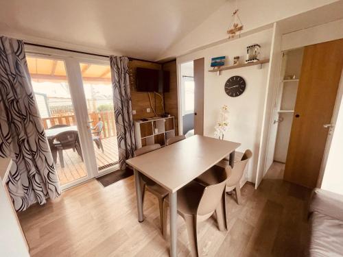 a kitchen and dining room with a table and chairs at Mobil Home Oliviers 2 in Valras-Plage