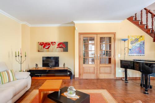a living room with a couch and a piano at CASA LAVANDA - very nice stylish house in Caldas da Rainha