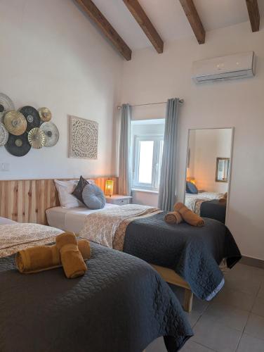 a bedroom with two beds and a mirror at Casa de Aloe in Albufeira