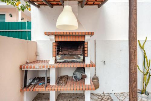 an outdoor pizza oven on a patio at CASA LAVANDA - very nice stylish house in Caldas da Rainha