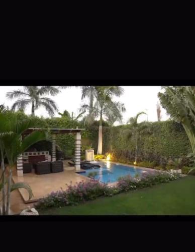 un patio trasero con piscina y jardín en فيلا فاخرة بحمام سباحة جراند هايتس, en Seis de Octubre