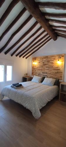 a bedroom with a large bed and a wooden wall at Casas las Lanzas 1 in Setenil
