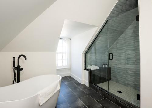 a bathroom with a tub and a glass shower at The August House in Windsor