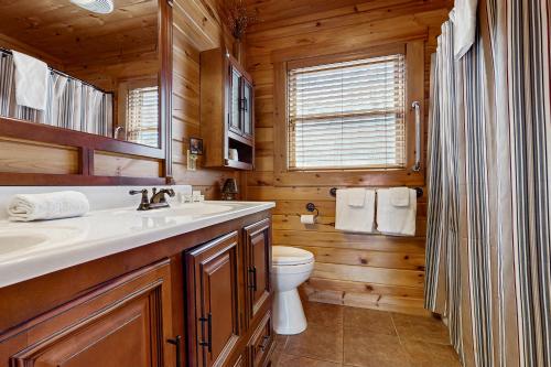a bathroom with a sink and a toilet in a log cabin at Big Sky in Whittier