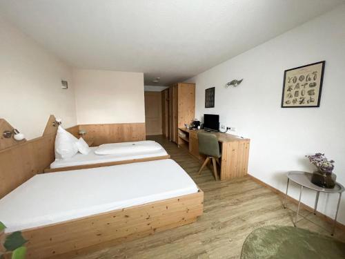 a bedroom with a large bed and a desk at Landhotel Waldheim in Pliezhausen
