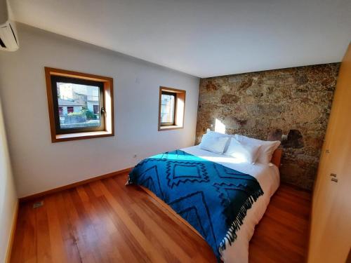 a bedroom with a large bed in a room at O Refúgio - Gerês in Souto