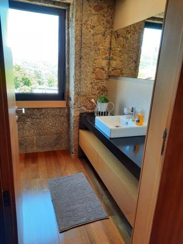 a bathroom with a sink and a window at O Refúgio - Gerês in Souto