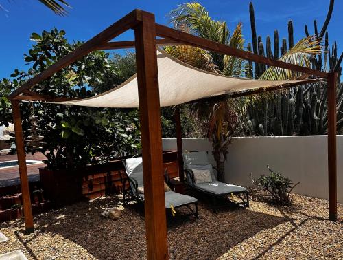 a patio with a hammock and chairs and plants at The Rocks Residence, apartment 1 of total 2 in Paradera