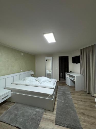 a bedroom with a large bed and a bathroom at Conacul Peștera Urșilor in Chişcău