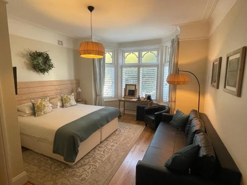 a bedroom with a bed and a couch at Beach Lodge in Bournemouth