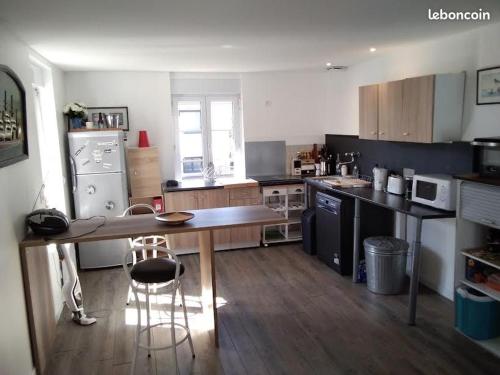 une grande cuisine avec une table et des chaises. dans l'établissement Appartement dans maison de caractère, à Saint-Malo