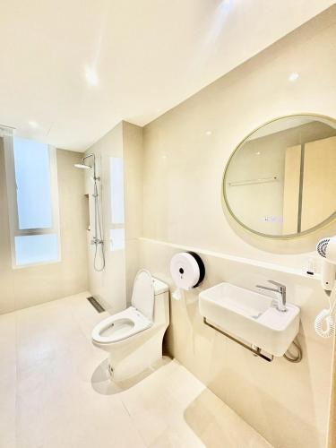 a bathroom with a toilet and a sink and a mirror at ABCQQ Hotel Bangkok in Bangkok
