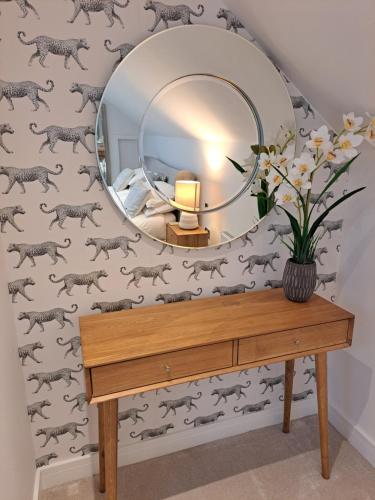 a dressing table with a mirror on a wall at Nanny lane loft in Church Fenton