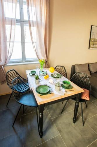 a dining room table with green plates on it at Kamienica Marianna in Reszel