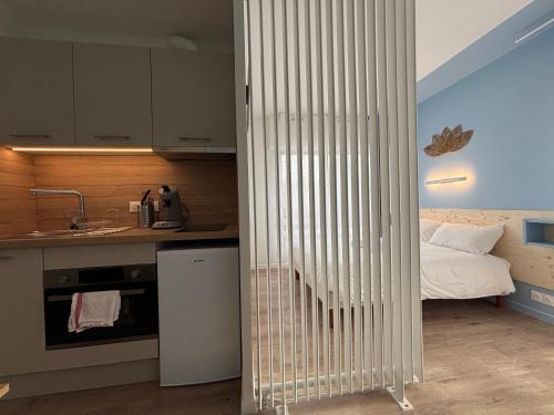 une chambre avec un lit bébé dans une cuisine avec un lit dans l'établissement Le D'Artagnan - App 8 - Balcon, à Cazaubon